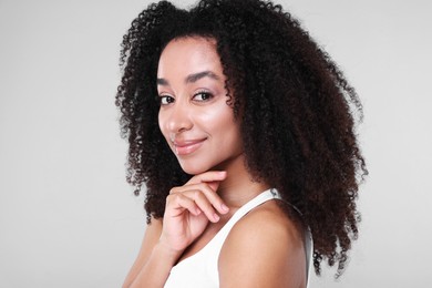 Photo of Beautiful Brazilian woman with healthy skin on gray background