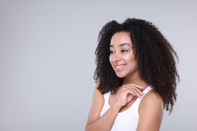 Photo of Beautiful Brazilian woman with healthy skin on gray background. Space for text