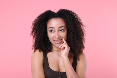 Photo of Beautiful Brazilian woman with healthy skin on pink background