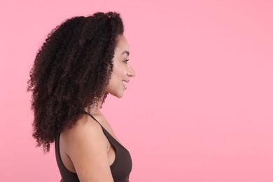 Photo of Beautiful Brazilian woman with healthy skin on pink background. Space for text
