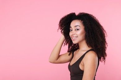 Photo of Beautiful Brazilian woman with healthy skin on pink background. Space for text