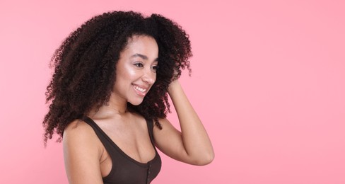 Photo of Beautiful Brazilian woman with healthy skin on pink background. Space for text