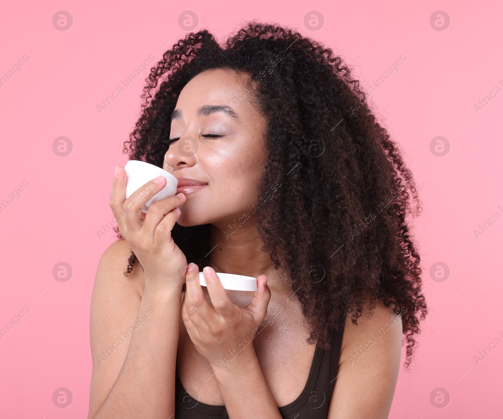 Photo of Beautiful Brazilian woman with jar of collagen cream on pink background