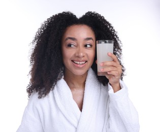 Photo of Beautiful Brazilian woman with glass of collagen water on white background