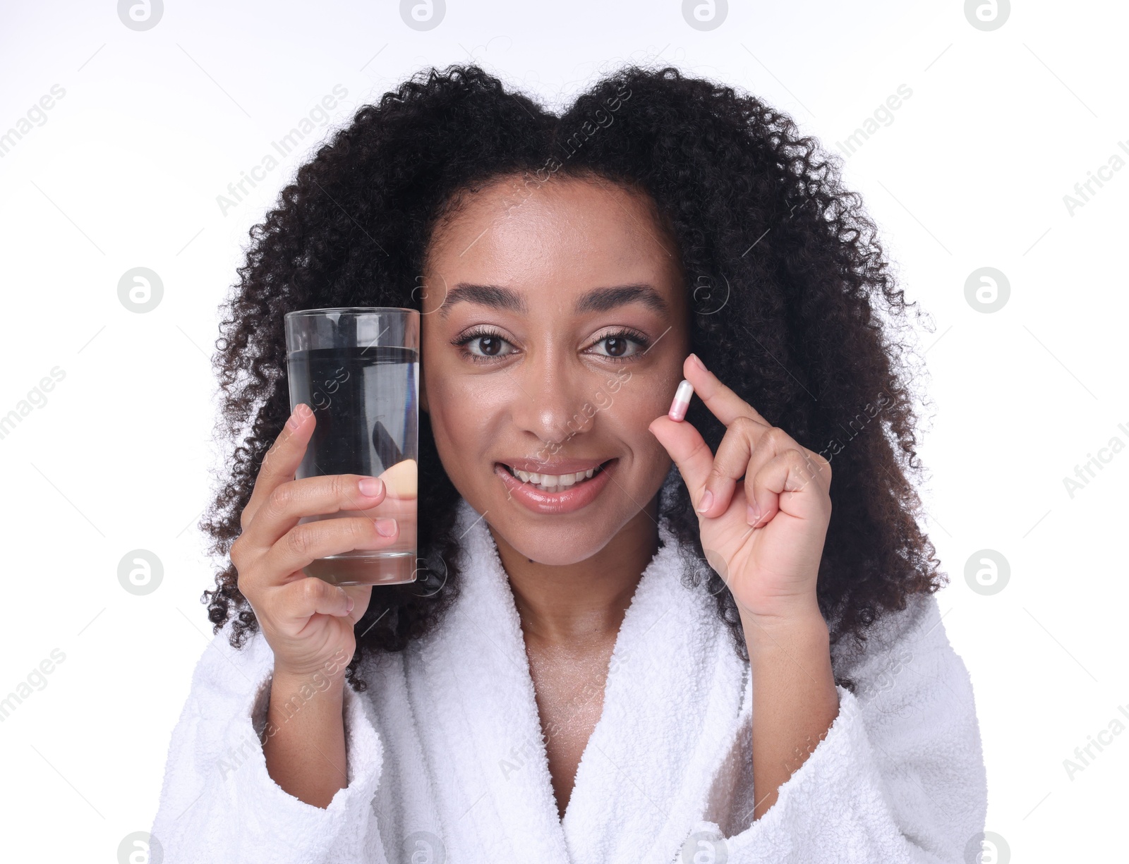 Beautiful Brazilian woman with glass of water and collagen pill on white background Photo of Beautiful Brazilian woman with glass of water and collagen pill on white background
