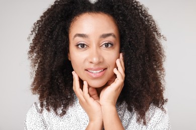 Photo of Beautiful Brazilian woman with healthy skin on gray background, closeup