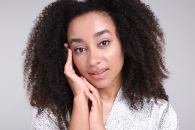 Photo of Beautiful Brazilian woman with healthy skin on gray background, closeup