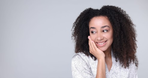 Photo of Beautiful Brazilian woman with healthy skin on gray background. Space for text