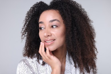 Photo of Beautiful Brazilian woman with healthy skin on gray background