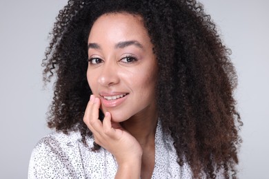 Photo of Beautiful Brazilian woman with healthy skin on gray background, closeup