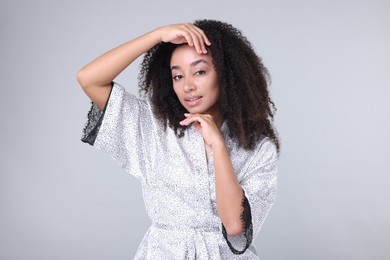 Photo of Beautiful Brazilian woman with healthy skin on gray background