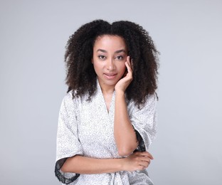 Photo of Beautiful Brazilian woman with healthy skin on gray background