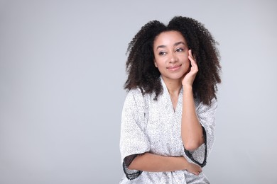 Photo of Beautiful Brazilian woman with healthy skin on gray background. Space for text