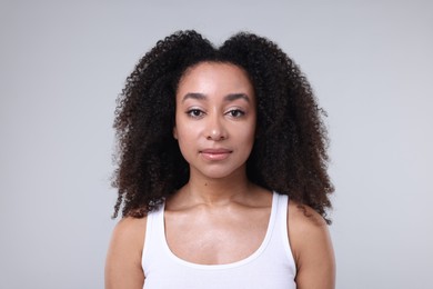 Photo of Beautiful Brazilian woman with healthy skin on gray background