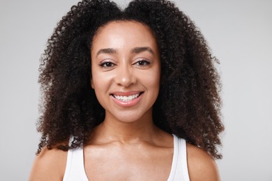 Photo of Beautiful Brazilian woman with healthy skin on gray background