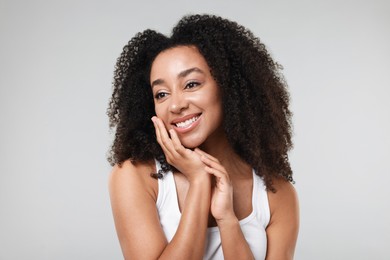 Photo of Beautiful Brazilian woman with healthy skin on gray background