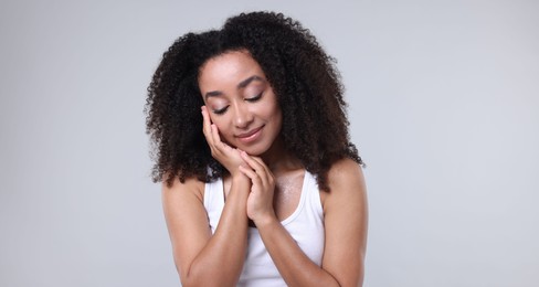 Photo of Beautiful Brazilian woman with healthy skin on gray background