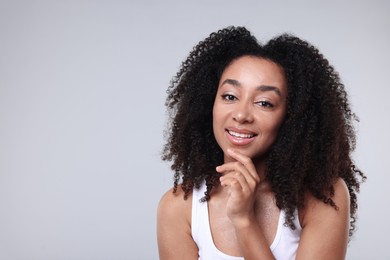 Photo of Beautiful Brazilian woman with healthy skin on gray background. Space for text