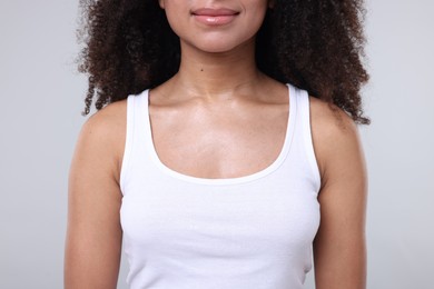 Photo of Brazilian woman with healthy skin on gray background, closeup