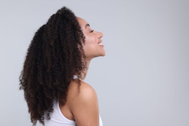 Photo of Beautiful Brazilian woman with healthy skin on gray background. Space for text