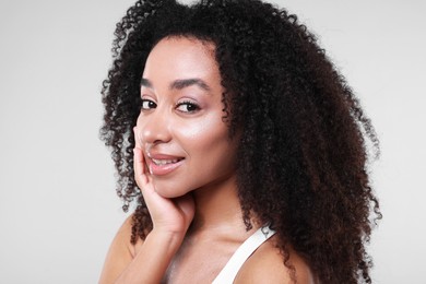 Photo of Beautiful Brazilian woman with healthy skin on gray background, closeup