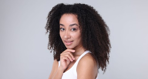 Photo of Beautiful Brazilian woman with healthy skin on gray background