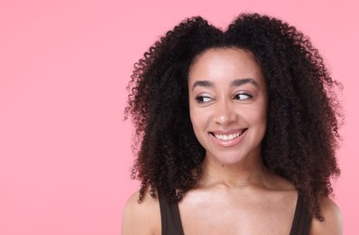 Photo of Beautiful Brazilian woman with healthy skin on pink background. Space for text