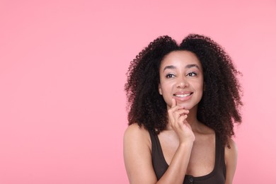Photo of Beautiful Brazilian woman with healthy skin on pink background. Space for text