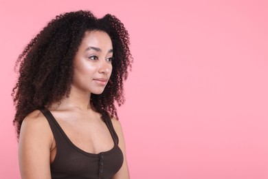 Photo of Beautiful Brazilian woman with healthy skin on pink background. Space for text