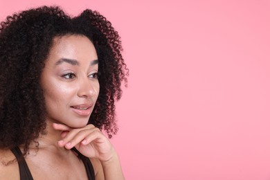 Photo of Beautiful Brazilian woman with healthy skin on pink background. Space for text