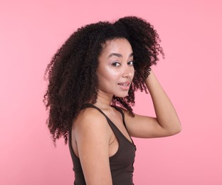 Photo of Beautiful Brazilian woman with healthy skin on pink background