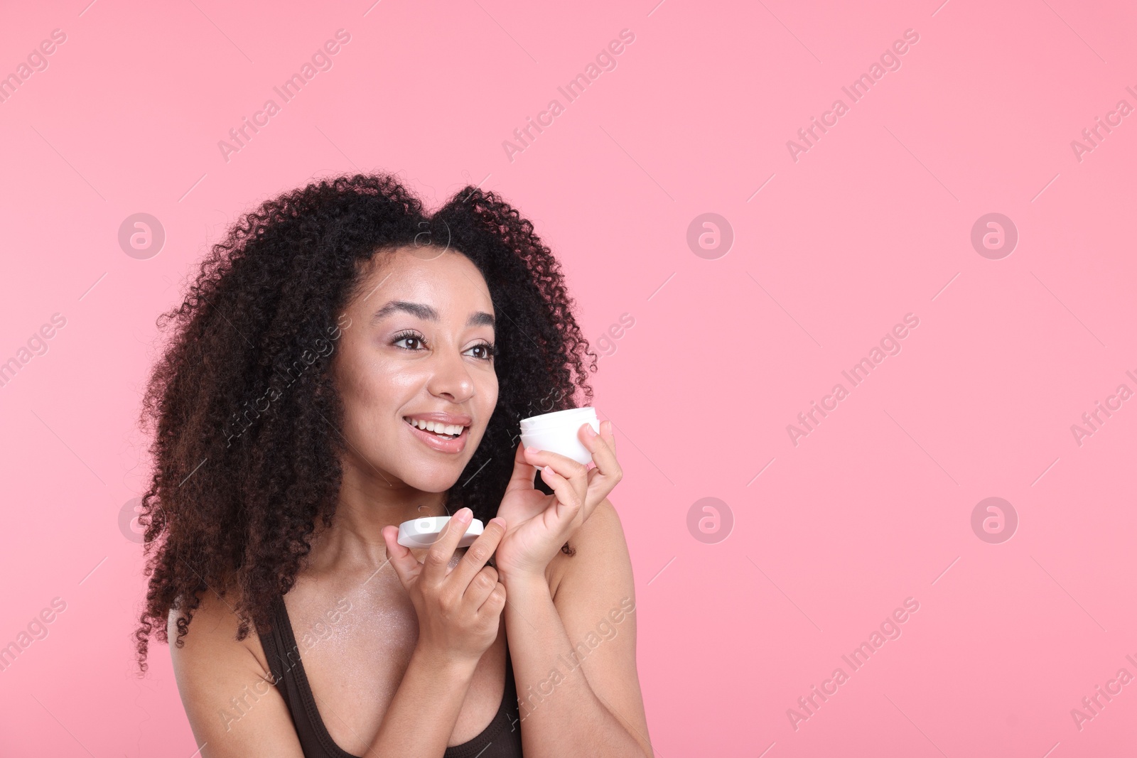Beautiful Brazilian woman with jar of collagen cream on pink background. Space for text Photo of Beautiful Brazilian woman with jar of collagen cream on pink background. Space for text