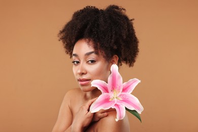 Photo of Portrait of beautiful Brazilian woman with lily flower after spa treatment on light brown background