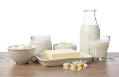 Photo of Different fresh dairy products and chamomile flowers on wooden table against white background