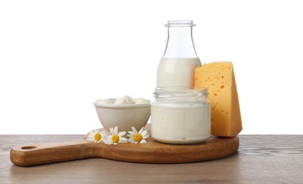Photo of Different fresh dairy products and chamomile flowers on wooden table against white background