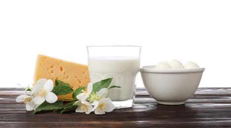Photo of Different fresh dairy products and flowers on wooden table against white background
