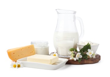 Photo of Different fresh dairy products and flowers isolated on white