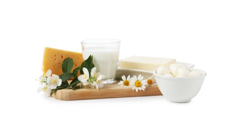 Photo of Different fresh dairy products and flowers isolated on white