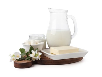 Photo of Different fresh dairy products and flowers isolated on white