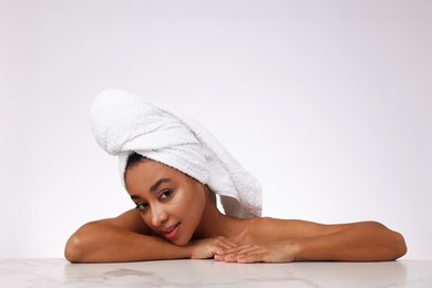 Photo of Portrait of beautiful Brazilian woman after spa treatment at gray marble table on light background