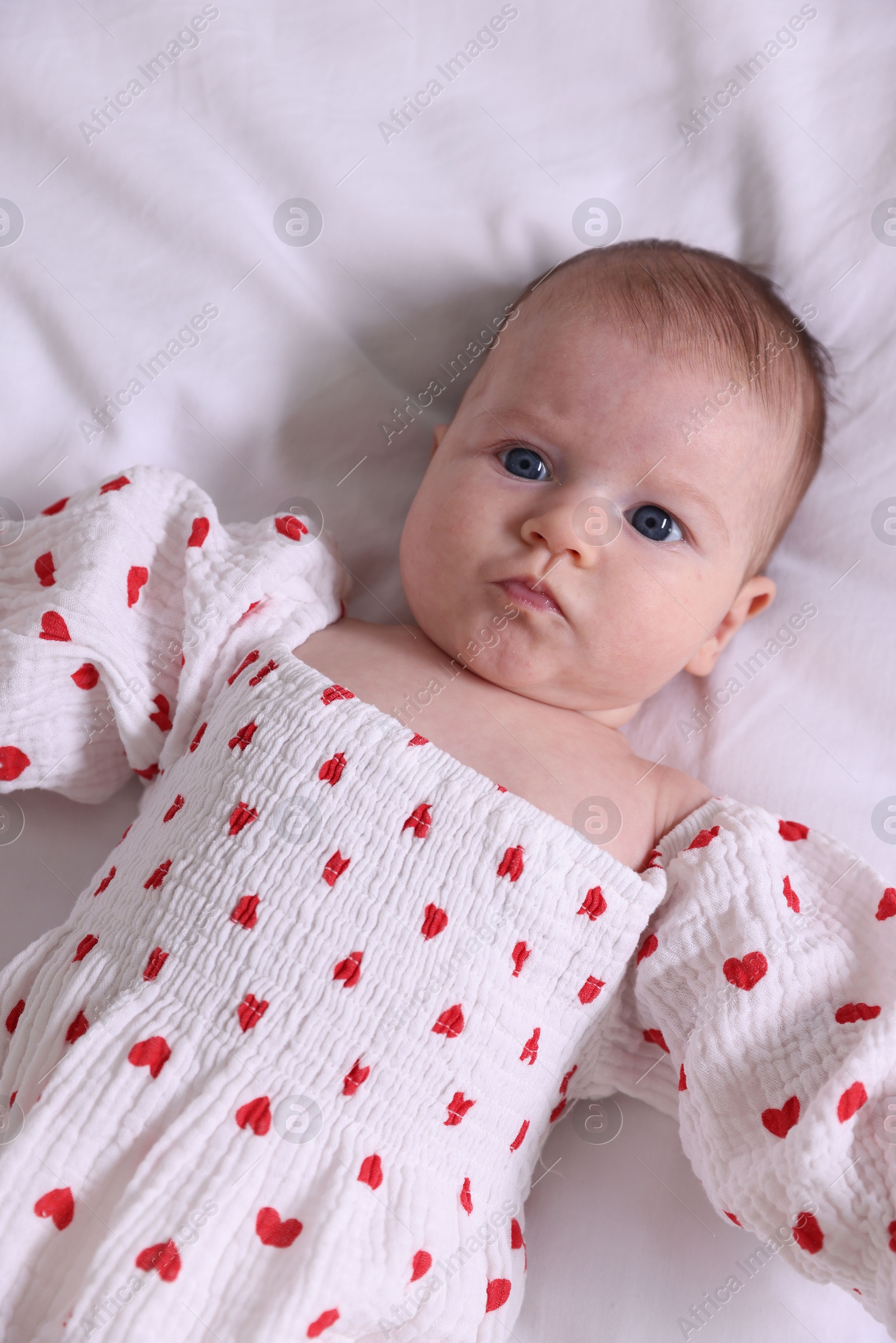 Photo of Cute newborn baby lying on bed, top view