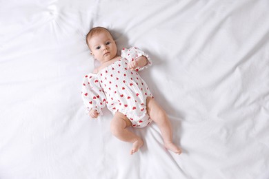 Photo of Cute newborn baby lying on bed, top view