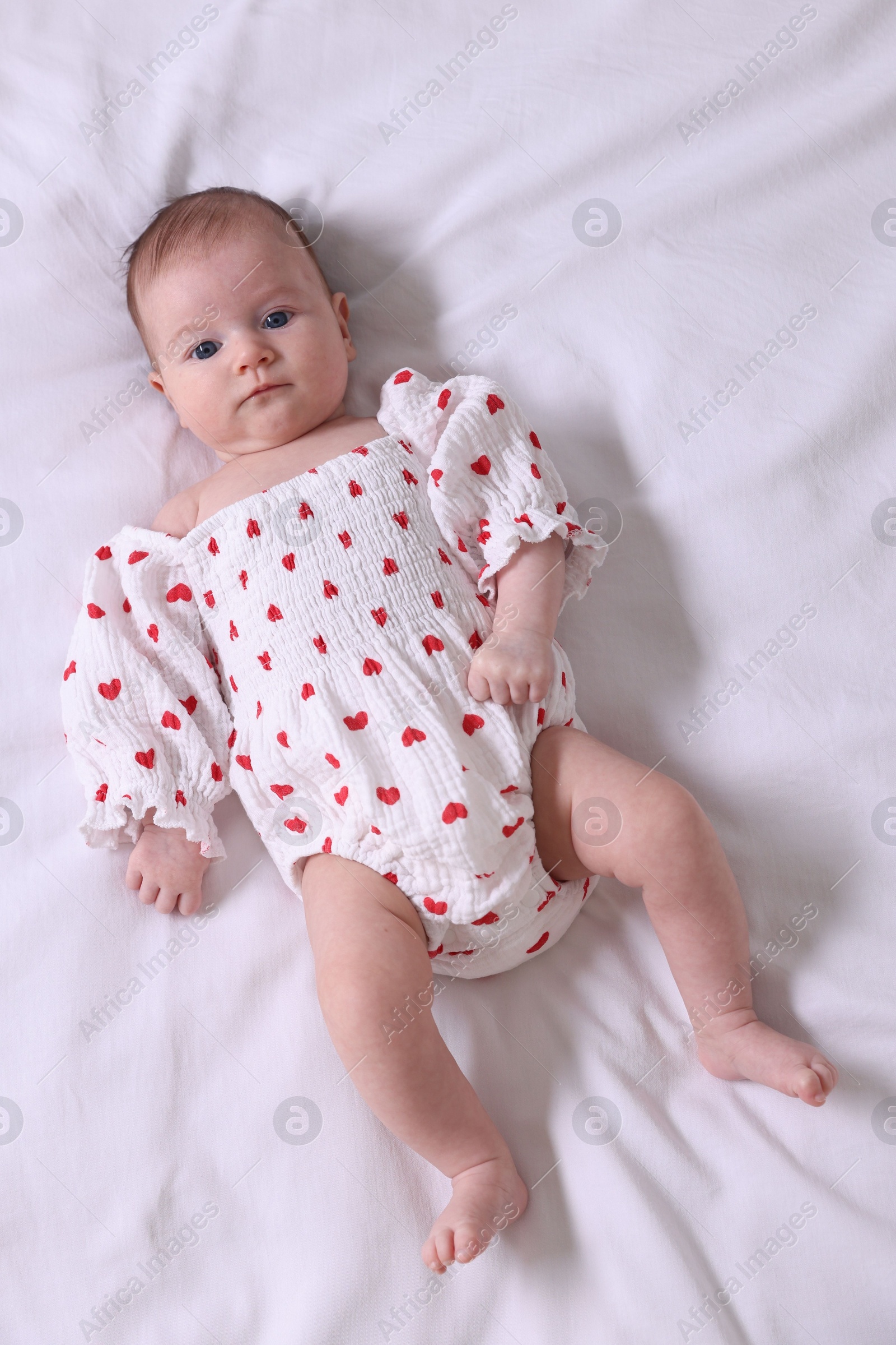 Photo of Cute newborn baby lying on bed, top view