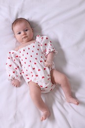 Photo of Cute newborn baby lying on bed, top view