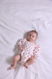 Photo of Cute newborn baby lying on bed, top view