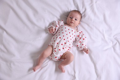 Photo of Cute newborn baby lying on bed, top view