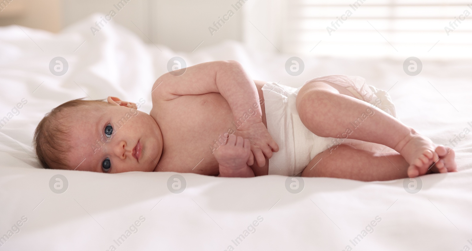 Cute newborn baby lying on bed indoors Photo of Cute newborn baby lying on bed indoors