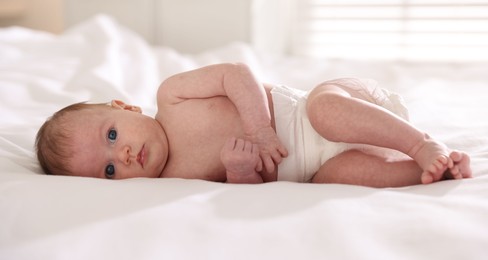 Photo of Cute newborn baby lying on bed indoors