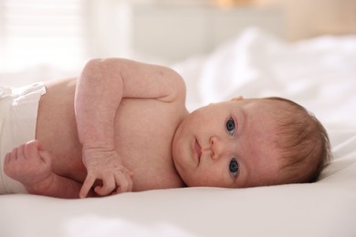 Photo of Cute newborn baby lying on bed, closeup