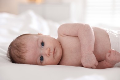 Photo of Cute newborn baby lying on bed, closeup